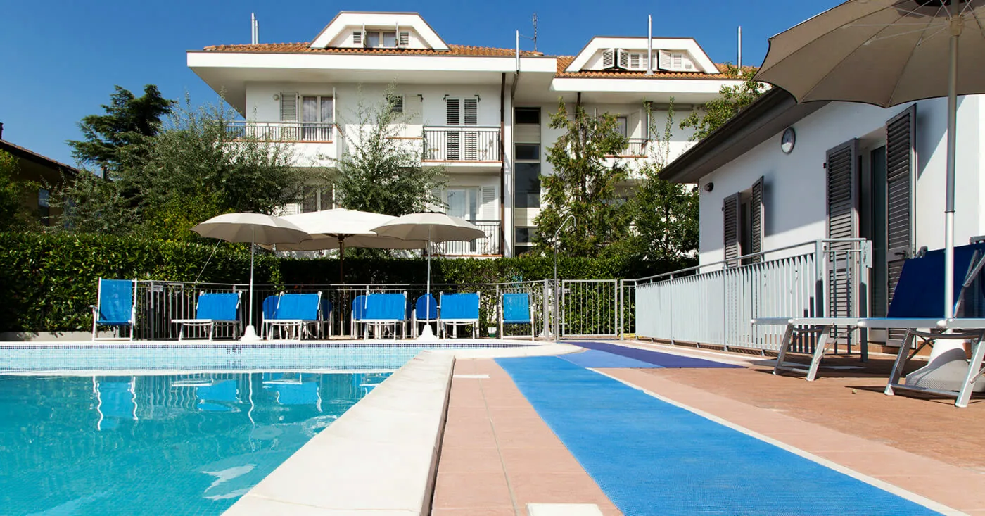 La piscina vista da bordo vasca, con gli appartamenti dietro