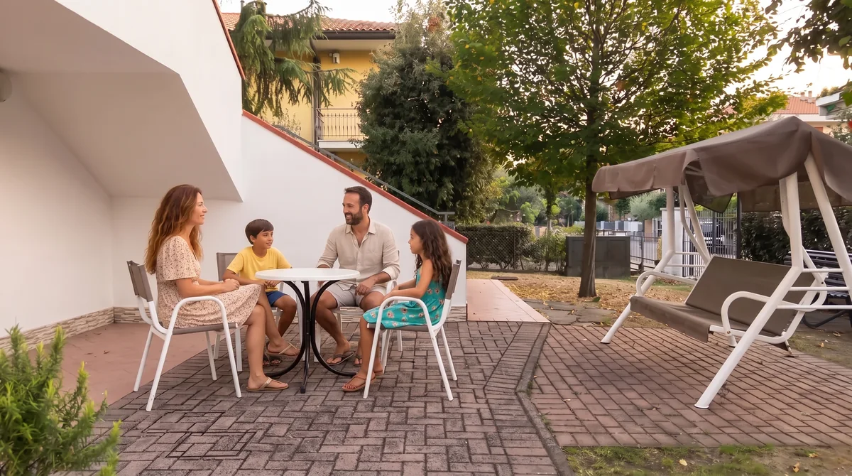 La famiglia seduta a chiacchierare al tavolino del patio, sotto la scala