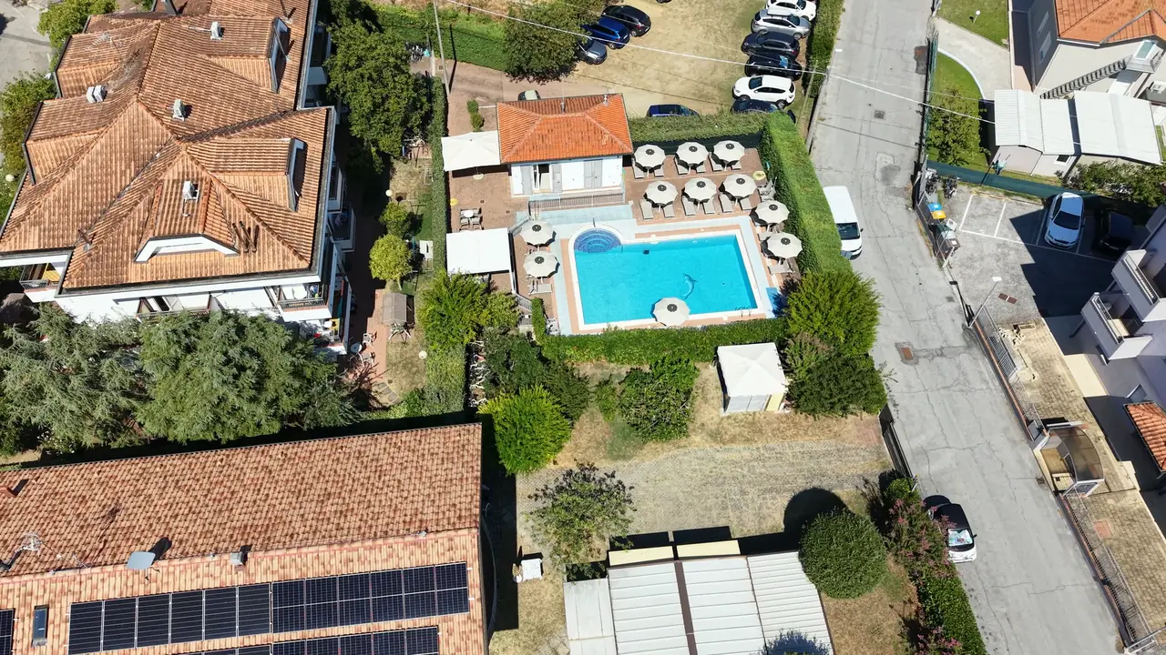 Il Residence Il Villaggio visto dal drone, con la piscina tra il verde e gli ombrelloni