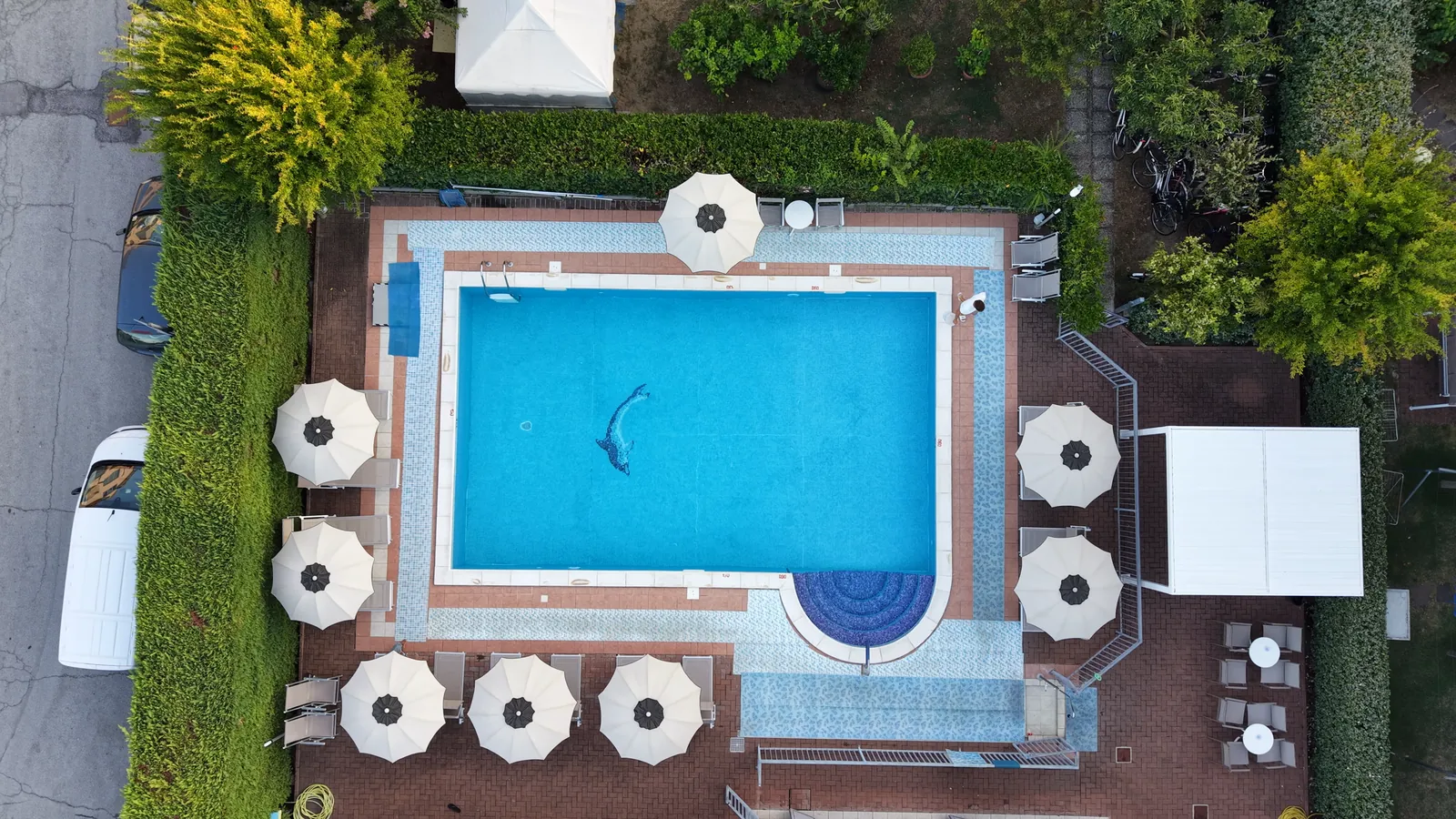 La piscina vista dall&rsquo;alto, con gli ombrelloni tutto intorno alla vasca