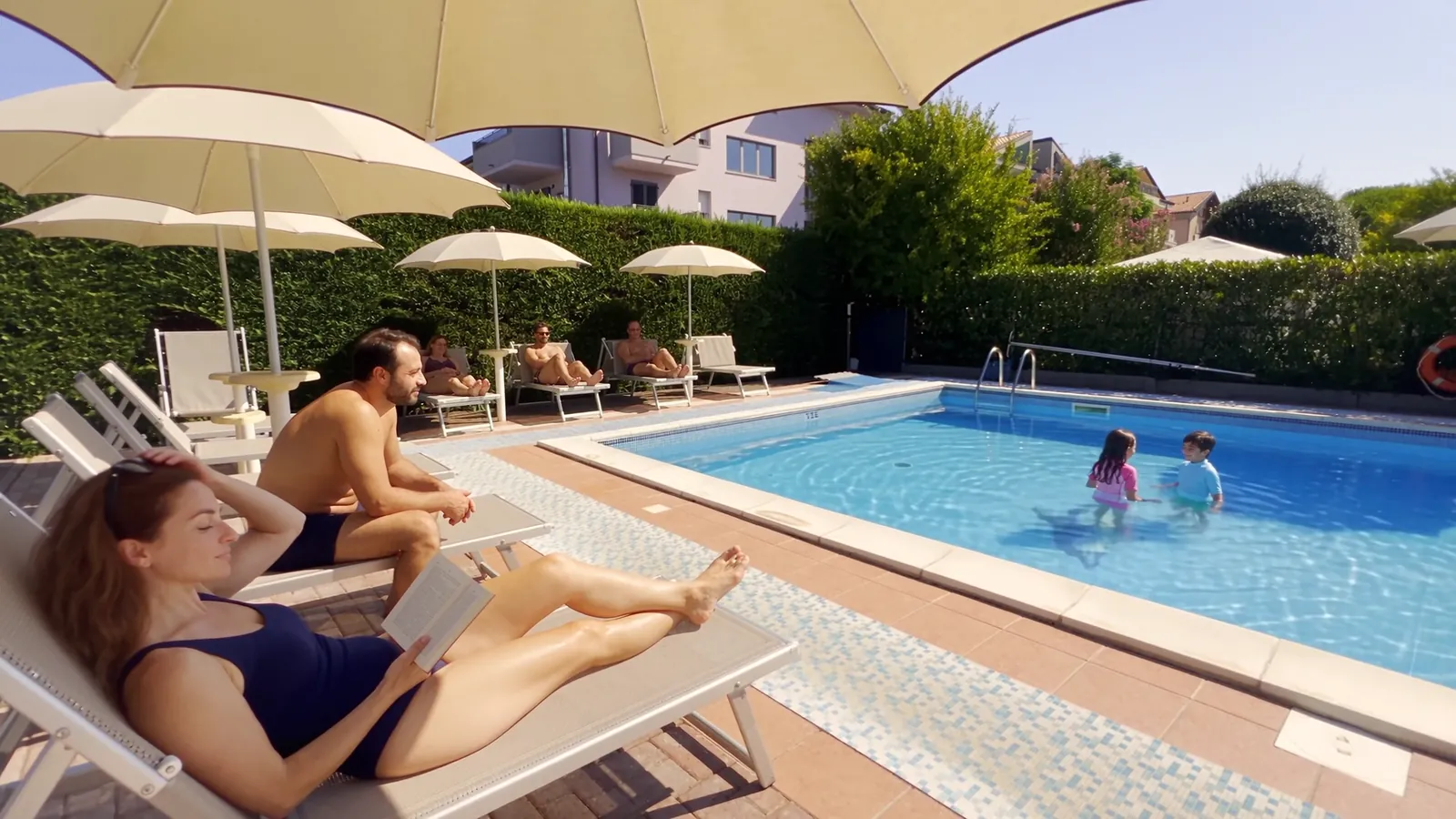 Il solarium con i lettini: i genitori si rilassano, i bambini giocano in acqua